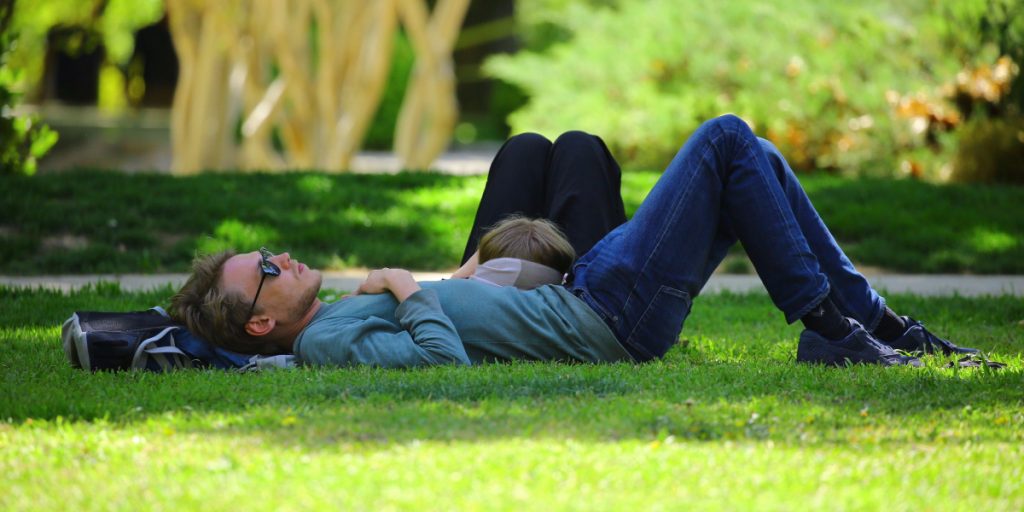 guy lying on the grass using Thich Nhat Hanh mindfulness techniques